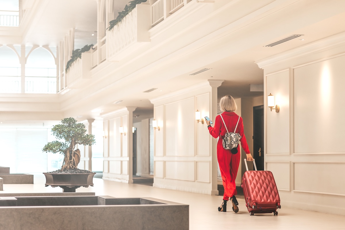 Stay here and feel like home. Attractive businesswoman arriving at luxury hotel. Copy space on the left side